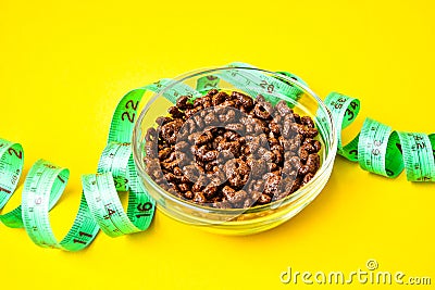 Bowl with chocolate corn flakes. green centimeter tape, healthy eating, diet Stock Photo