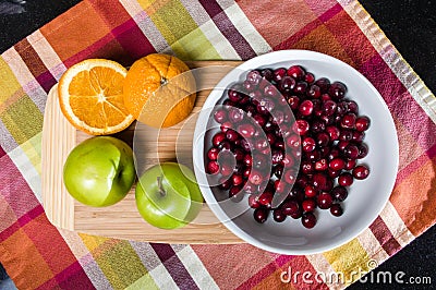 Bowl of cranberries with apples and oranges Stock Photo