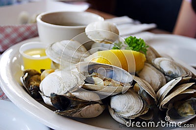 Bowl of Delicious Fresh Steamer Clams with Lemon and Broth Stock Photo