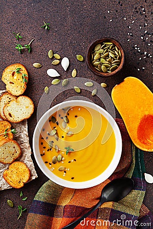 Bowl with diet autumn pumpkin cream soup served with seeds and crouton on stone table top view Stock Photo