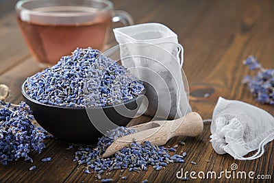 Bowl of dry healthy lavender, tea bag with lavender flowers. Glass tea cup with herbal tea on table. Stock Photo