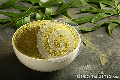 Organic green neem leaves powder in ceramic bowl. Stock Photo