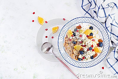 Bowl of flakes with cottage cheese and yogurt blueberryes and pomegranate Stock Photo