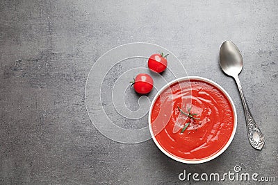 Bowl with fresh homemade tomato soup and on grey background, top view Stock Photo