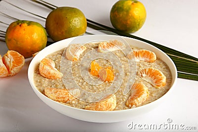 Bowl of fresh oatmeal porridge with orenges Stock Photo