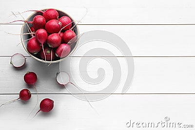 Bowl with fresh ripe radishes on white wooden table, flat lay. Space for text Stock Photo