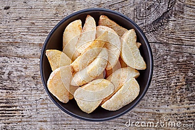 Bowl of frozen potato wedges on wood, from above Stock Photo