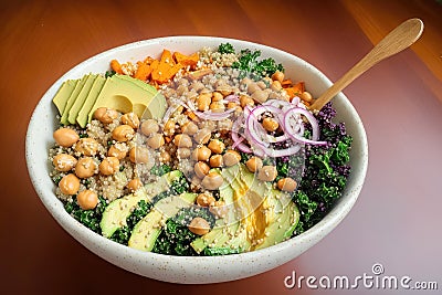 a bowl full of healty food, quinoa base, roasted sweet potatoes, steamed kale, fresh avocado Stock Photo