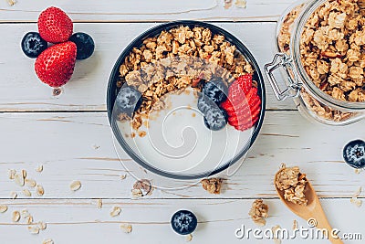 Bowl of granola with yogurt, fresh berries, strawberry on wood t Stock Photo