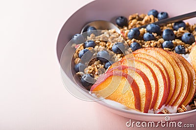 Bowl of granola with yogurt, peach slices and bluberry Stock Photo