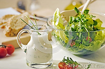 Bowl of greens and salad dressing Stock Photo