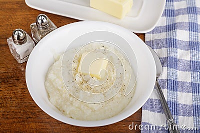 Bowl of Grits with Butter and Pepper Stock Photo