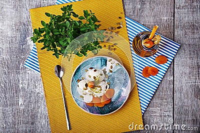 A bowl of ice cream, a bottle of apricot juice and decorative tree on a wooden background. Top view of a light dinner. Stock Photo