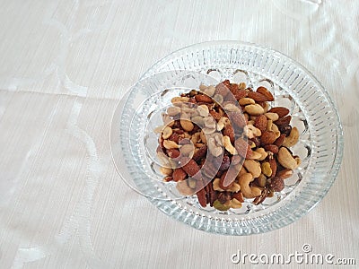 Bowl of mixed nuts on a plain white tablecloth Stock Photo