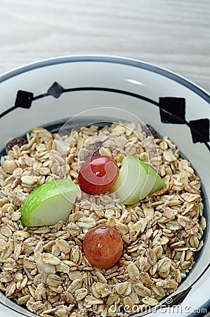 A bowl of muesli with pieces of apple and grapes Stock Photo