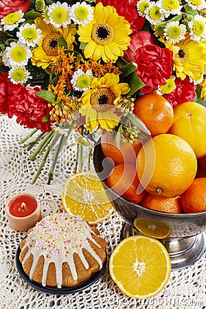 Bowl of oranges and bouquet of gerbera and carnation flowers Stock Photo