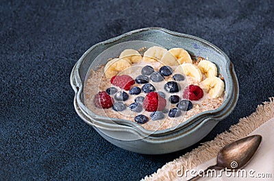 Bowl of organic steel cut oats topped with banana and berries; copy space Stock Photo