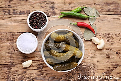 Bowl of pickled cucumbers and ingredients for food preservation on wooden table, flat lay Stock Photo