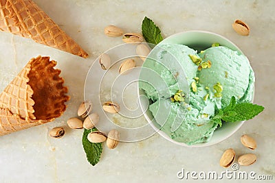 Bowl of pistachio ice cream, above scene over white marble Stock Photo