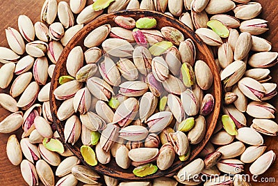 Bowl of pistachio nuts on wooden table top view. Healthy food and snack. Stock Photo
