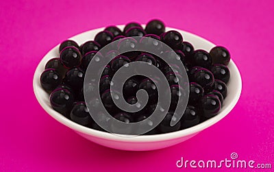 Bowl of Popping Boba Pearls on a Bright Pink Background Stock Photo