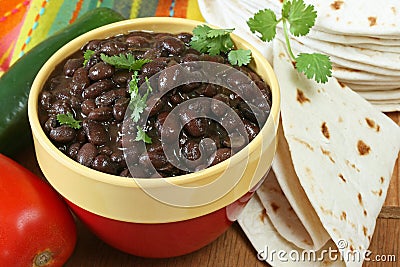 Bowl of prepared black beans with tortillas Stock Photo