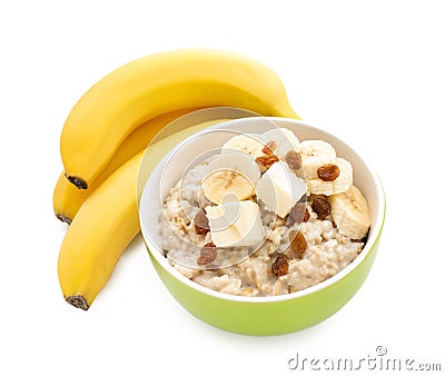 Bowl with prepared oatmeal, raisins and bananas on white background Stock Photo