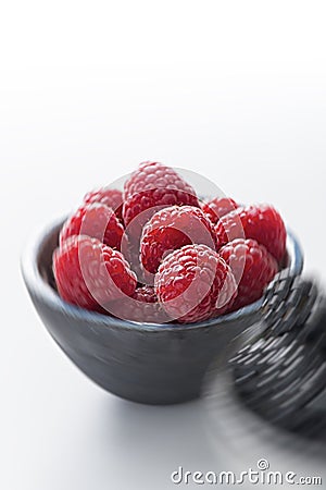 Bowl of raspberries against white background Stock Photo