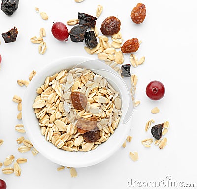 Bowl with raw oatmeal, raisins and cranberries on white background Stock Photo