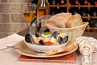 Bowl of seafood soup with wine and rustic bread Stock Photo