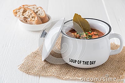 Bowl with Solyanka, a spicy and sour soup of Russian origin, on white wooden table Stock Photo