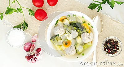 bowl of soup, a cup of broth and vegetables, meatballs made of turkey and chicken, top view, long width banner Stock Photo