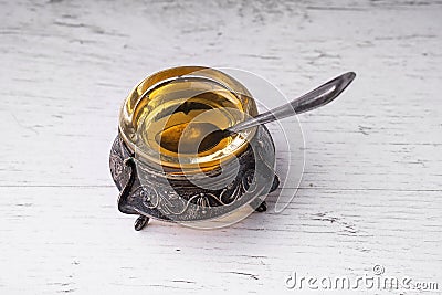 Bowl with a spoon with honey antique silver Stock Photo