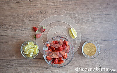 A bowl of strawberries, a lemon and brown sugar. Stock Photo