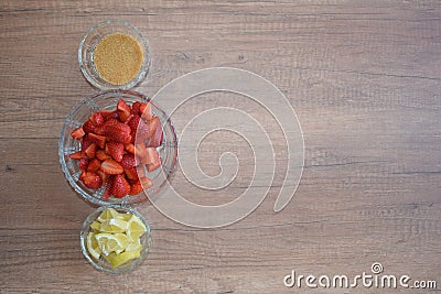 A bowl of strawberries, a lemon and brown sugar. Stock Photo