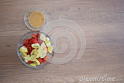 A bowl of strawberries, a lemon and brown sugar. Stock Photo