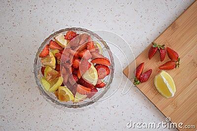 A bowl of strawberries, a lemon and brown sugar. Stock Photo