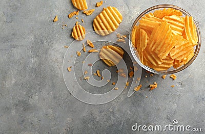 Bowl with tasty crispy potato chips on grey table Stock Photo