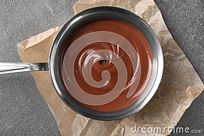 Bowl with tasty melted chocolate on grey table, top view Stock Photo