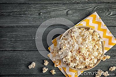 Bowl of tasty popcorn on wooden background, top view Stock Photo