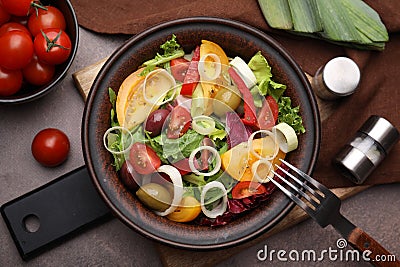 Bowl of tasty salad with leek and olives served on brown table, flat lay Stock Photo