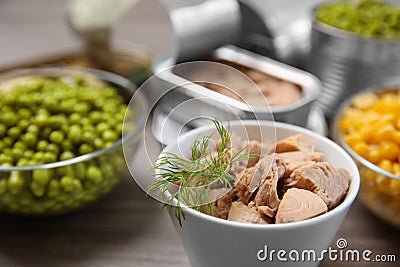 Bowl of tuna and canned products on table. Space for text Stock Photo