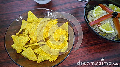 Bowl of tuna salad, tortilla chips, olives and glass of red wine Stock Photo