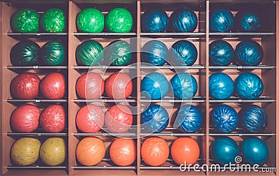 Bowling balls in the rack, sorted by color Stock Photo