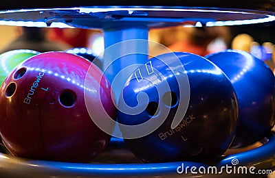 Brunswick bowling balls under UV light in bowling alley Editorial Stock Photo