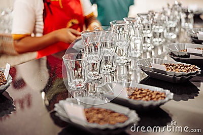 Bowls of coffee beans and empty glasses for tasting Stock Photo