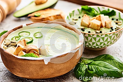 Bowls with delicious green vegetable creamy soup with croutons. Stock Photo