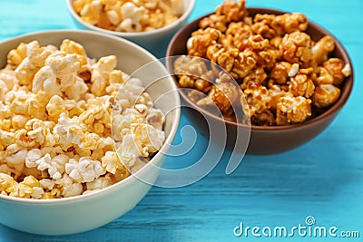 Bowls with delicious popcorn on wooden background, closeup Stock Photo