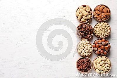 Bowls with different organic nuts and space for text on wooden background, top view. Snack mix Stock Photo