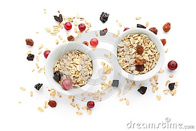 Bowls with raw oatmeal, raisins and cranberries on white background Stock Photo